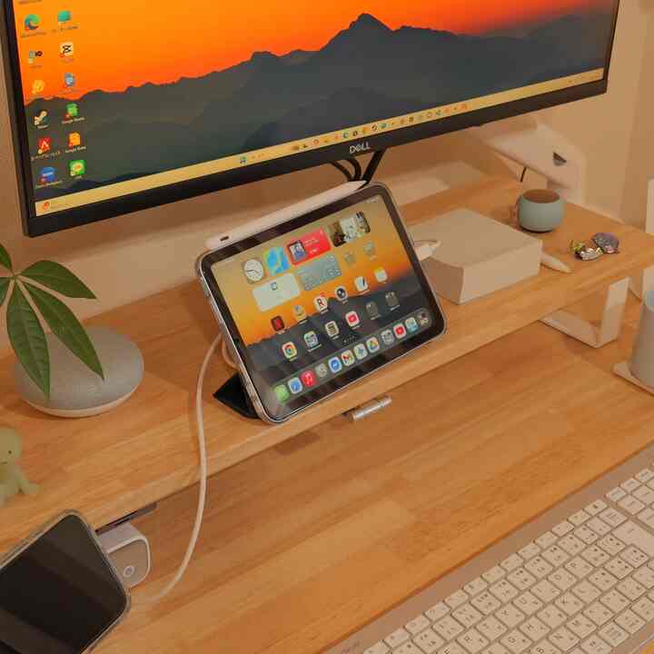 Natural toned home office featuring a wooden desk with an iPad mini and monitor arranged for a cozy work setup