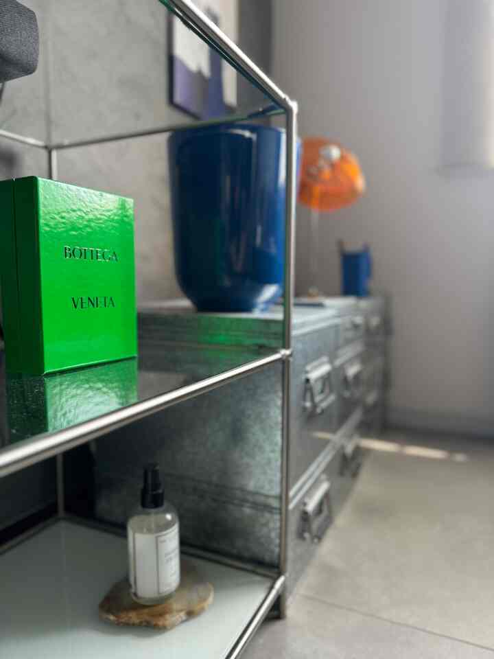 緑・青・オレンジの色調で、金属製収納棚と装飾品が配置された印象的なインテリア