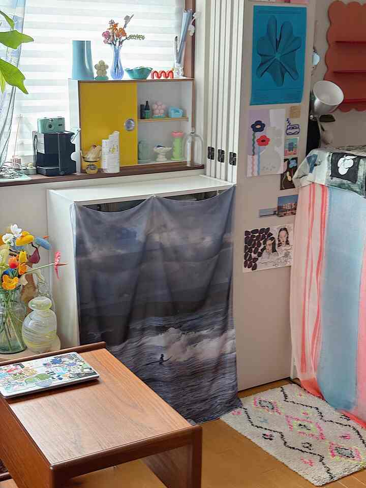 明るい色調のリビング、木製コーヒーテーブルと多彩な小物が配置された温かみのある空間