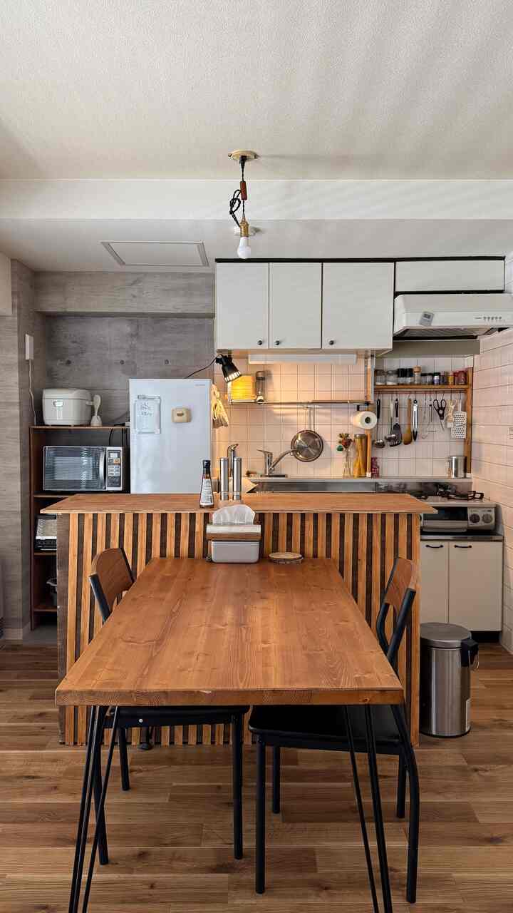 木目調と白の調和が取れたキッチン・ダイニング空間、ステンレス家具がアクセントの清潔感あるインテリア