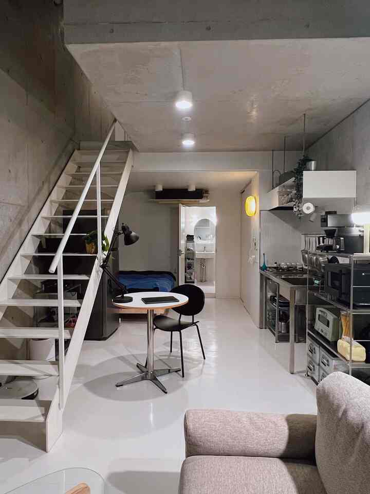 白とグレーのトーンのワンルーム、効率的なレイアウトとモダンな家具が配置された雰囲気のあるインテリア