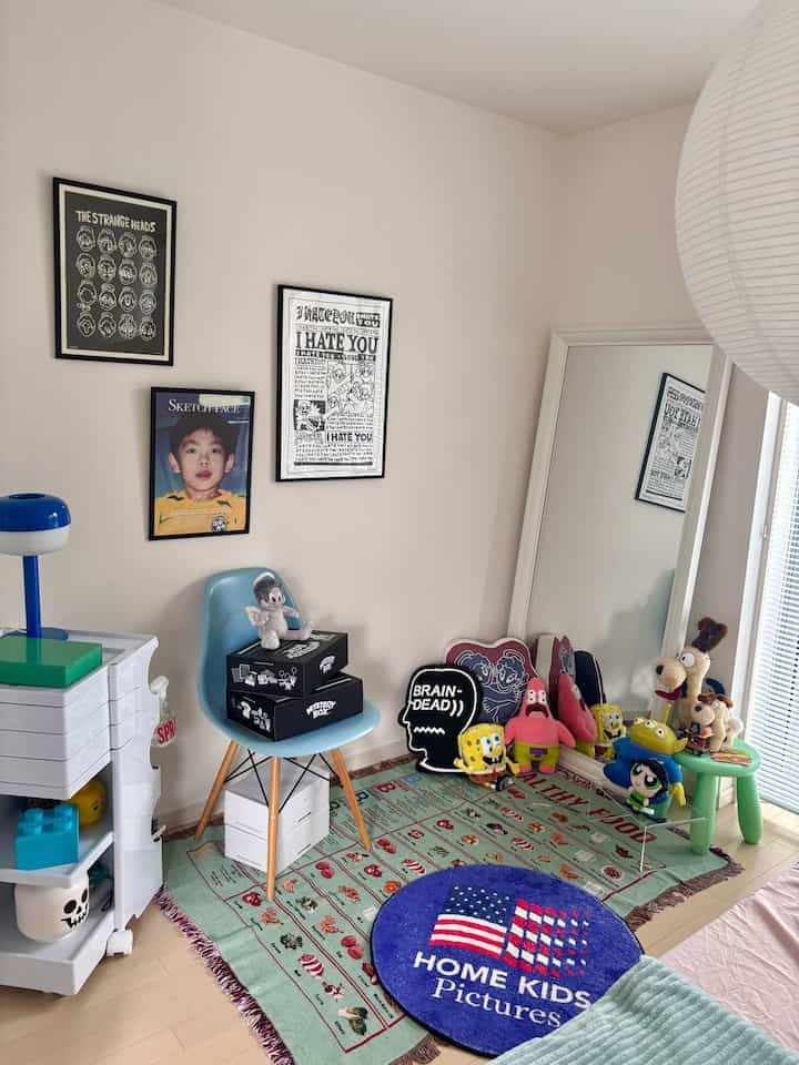 ナチュラルカラーの子供部屋、ブルースツールと大型の全身鏡、ぬいぐるみとヴィンテージ風ポスターが配置された雰囲気のあるインテリア