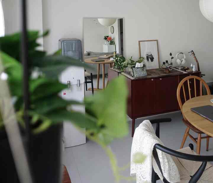 白と茶色のナチュラルでミニマルなダイニングとリビング空間、木製家具と大きな鏡が配置された雰囲気あるインテリア