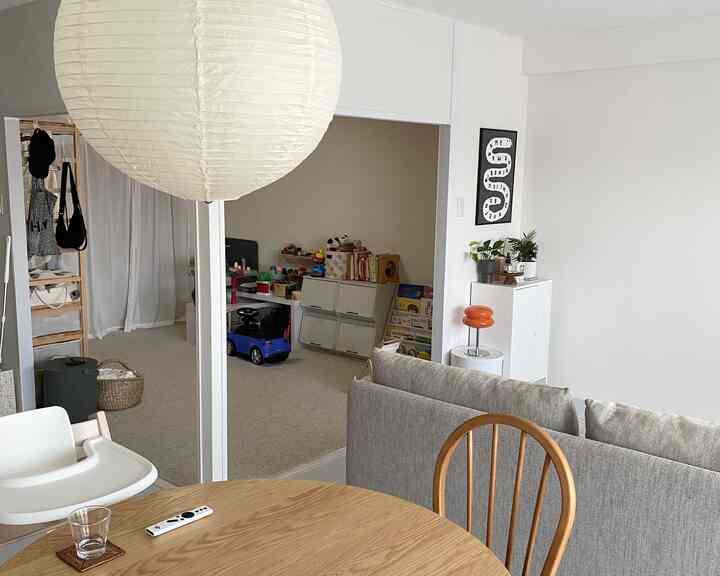 白とナチュラルトーンのダイニングルームと隣接する、おもちゃや収納のある子供部屋が特徴的な印象的な空間
