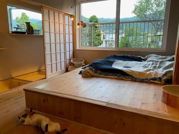 ナチュラルな木目調の和モダンな寝室、障子戸と窓辺に猫がいる雰囲気のある空間