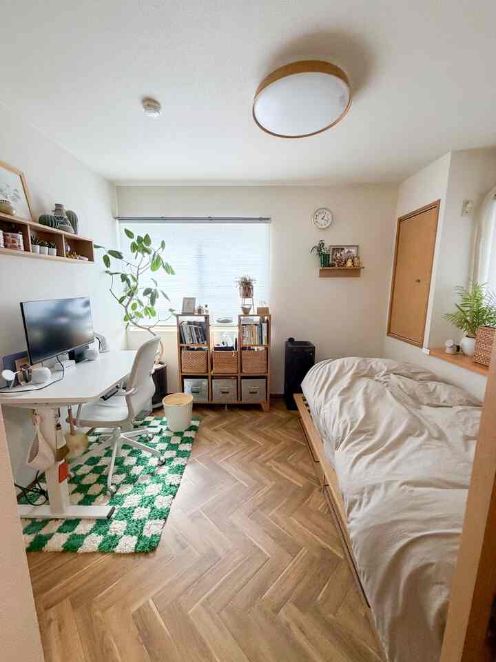 ナチュラルな木目調の6畳寝室、ワークデスクと棚が配置されたコンパクトな一人暮らしの空間