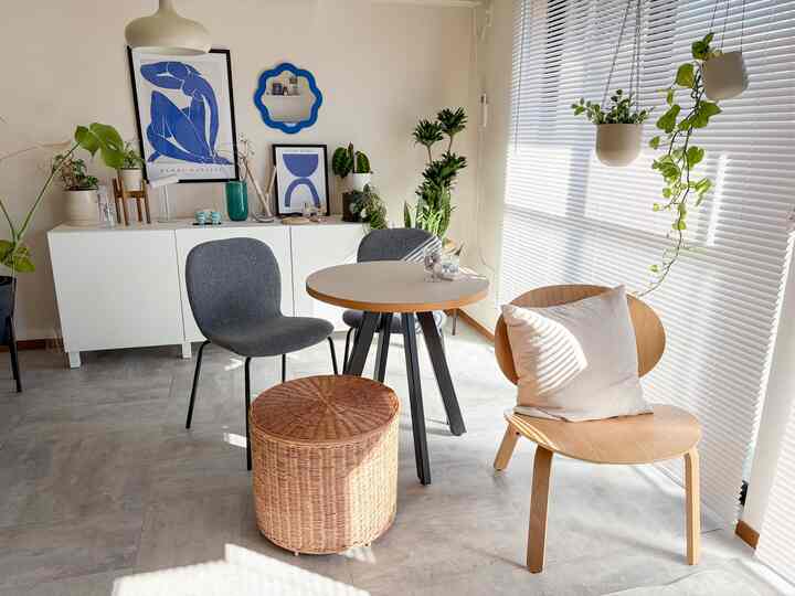 明るい白と木目調が調和したダイニング、テーブルと椅子、植物が配置されたシンプルで自然な雰囲気のあるインテリア