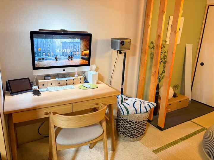 ウッドトーンと白の畳の部屋のホームオフィス、木製の机と椅子、壁付けの照明が配置された落ち着いた雰囲気のインテリア