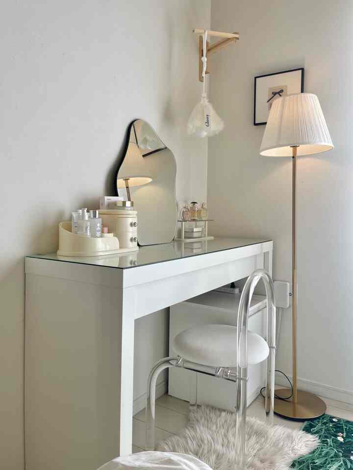 白とゴールドの色調のパウダールーム、化粧台とクリアチェアが配置されたシンプルでナチュラルな雰囲気のあるインテリア