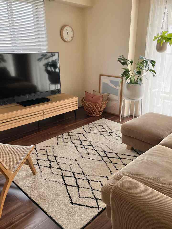 ベージュのソファと木目調の家具が配置された暖かくナチュラルな雰囲気のリビング