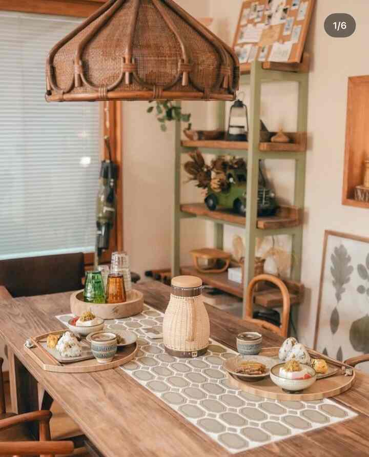 ナチュラルな木目調とベージュの色調が調和するダイニング、ダイニングテーブルと椅子、テーブルランナーと皿が配置された雰囲気のあるインテリア