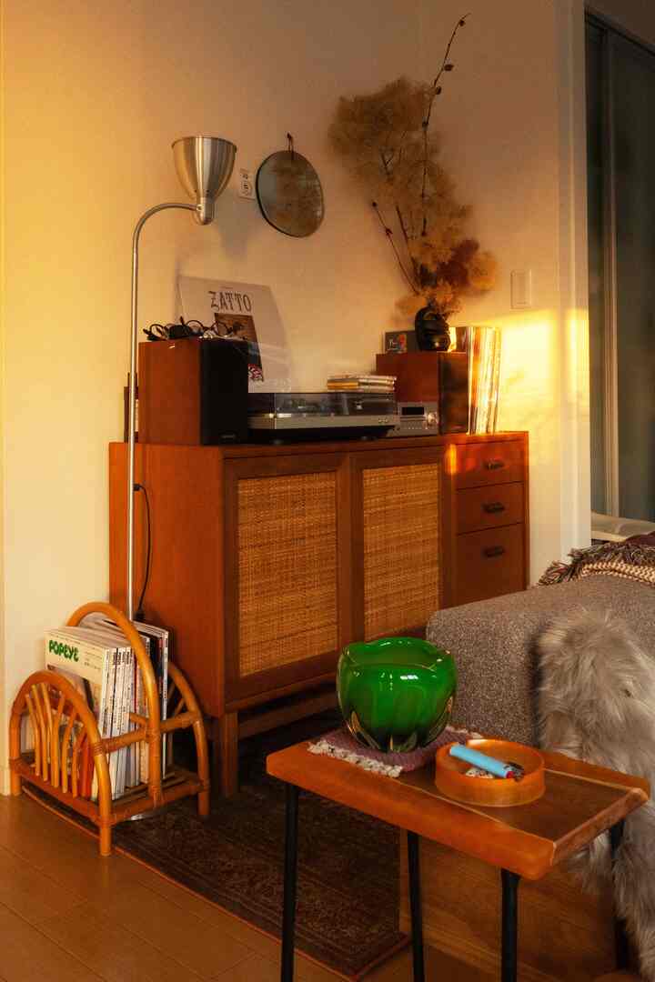 温かみのあるブラウンの木目調家具とレトロな雰囲気のリビング、音響機器とレコードが配置された居心地の良い空間