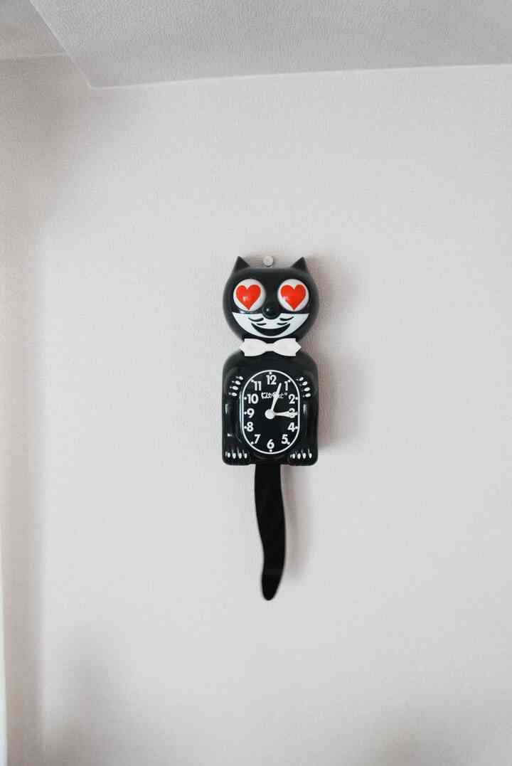 白い壁に黒い猫型の時計が赤いハートの目でアクセントとなったモダンなインテリア