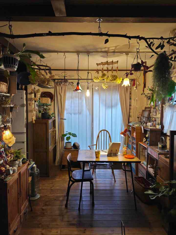 ナチュラルな茶色のキッチン空間、木製のダイニングテーブルやガーランド、暖かい照明が配置された居心地の良いインテリア