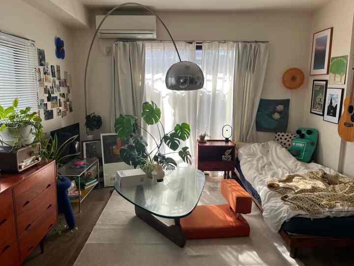 ブラウンウッドとグリーン植物が調和する8畳の寝室、ミッドセンチュリーモダンスタイルで落ち着いた雰囲気のインテリア