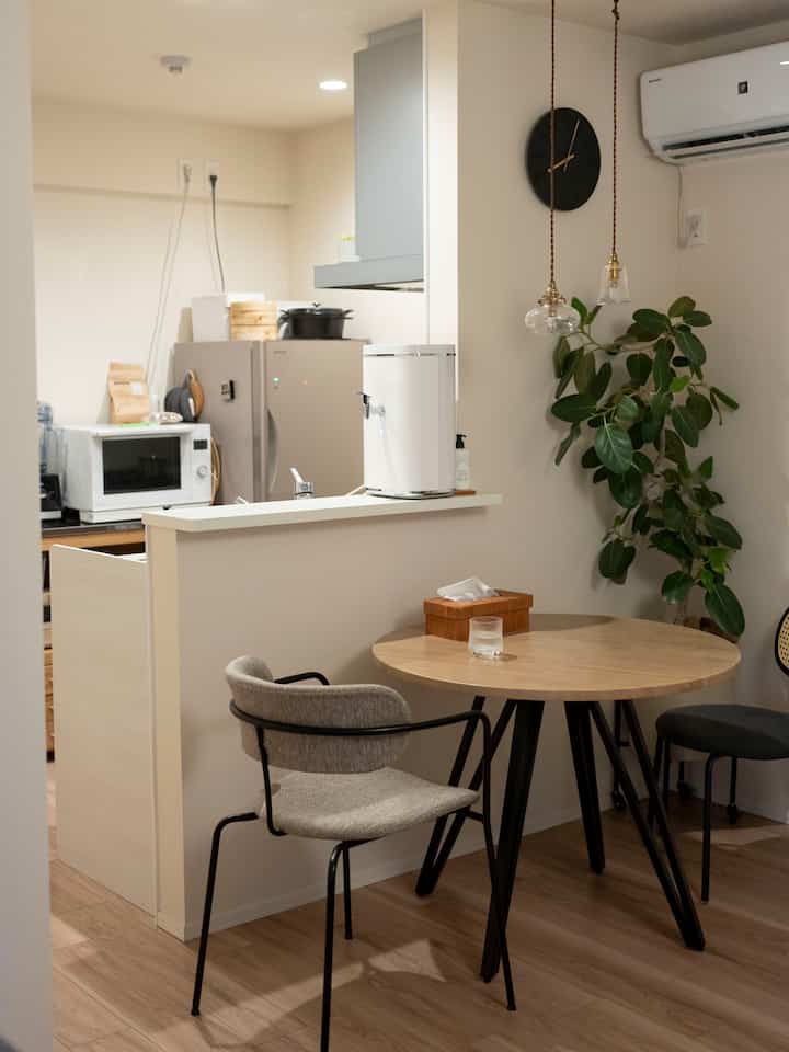 White and wood-toned kitchen and dining space with Nordic-style dining table and chairs creating a cozy atmosphere