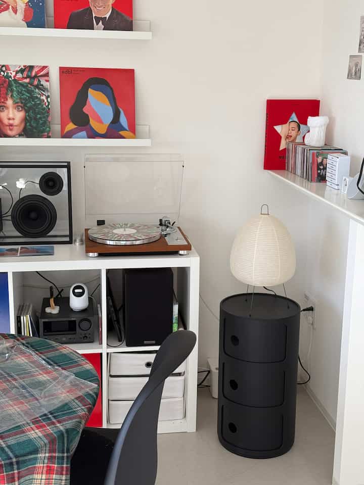 明るい白を基調とした韓国インテリアのリビング、ターンテーブルとレコードが配置された雰囲気のある空間