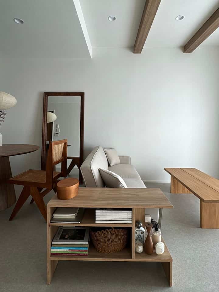 明るいオークの木目調と白い壁の和モダンなリビングとダイニング、シンプルなソファと木製家具が配置された空間