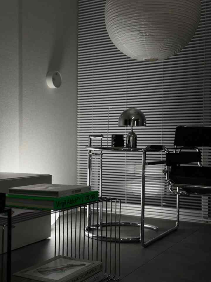 Modern black and white toned home office featuring chrome desk, office chair, paper lantern with sleek, stylish interior