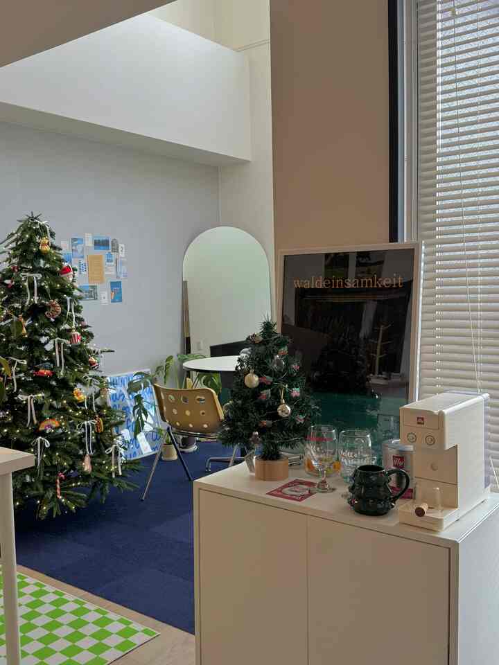 A white and beige toned studio apartment featuring Christmas trees and home cafe elements in a cozy interior