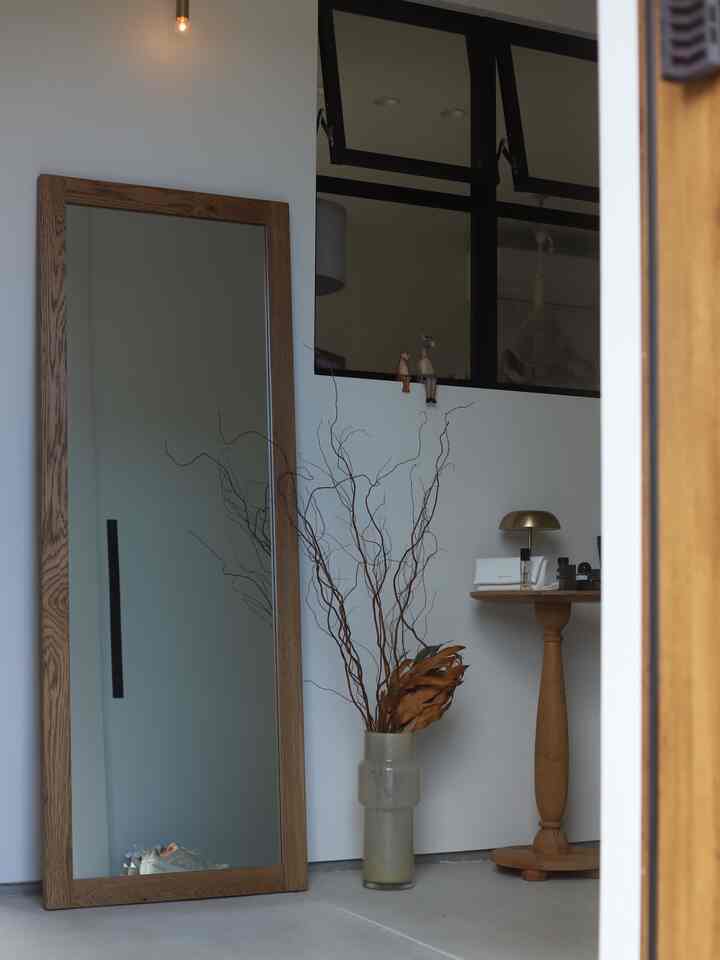 木目調家具と大きな鏡が配置されたシンプルでナチュラルな玄関の雰囲気あるインテリア