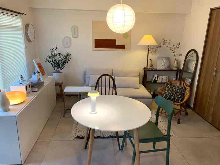 Beige and white toned 1LDK living room featuring sofa and round dining table arranged in a cozy natural interior