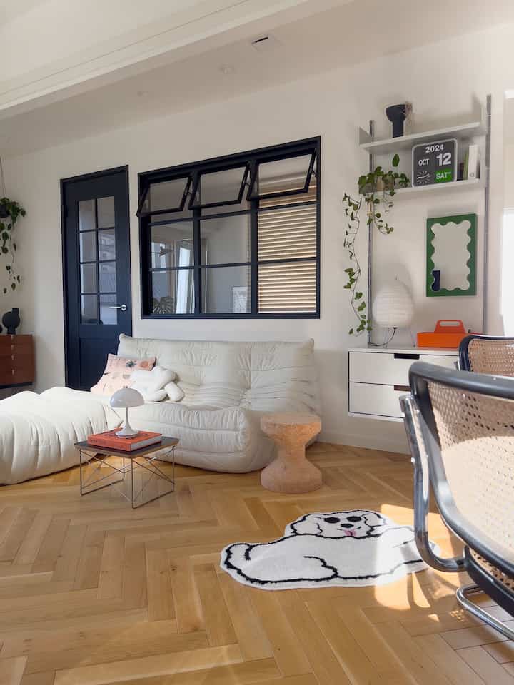White and wood tone living room featuring white sofa and cork stool creating a natural atmosphere