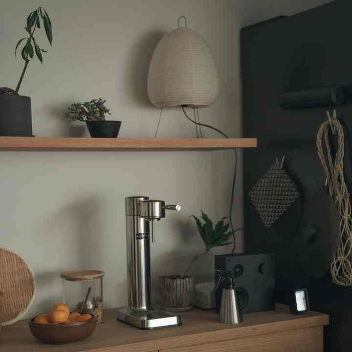 暖かみのあるブラウンとナチュラルな色調のホームカフェ空間、木製テーブルとイケアの収納アイテムが配置された印象的なインテリア