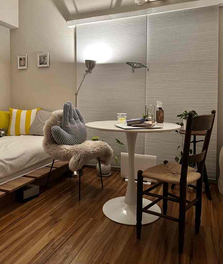 A white and brown toned balcony space featuring modern furniture and natural elements in a cozy setting
