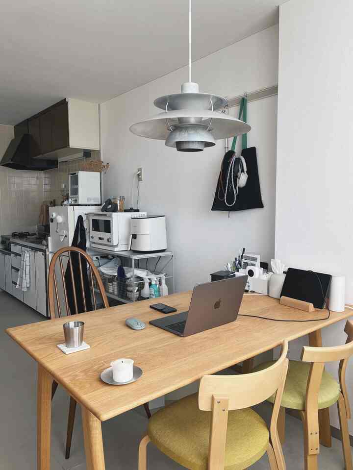 白い壁とナチュラルな木目調のダイニングテーブルがある一人暮らし向けのキッチンダイニング、シンプルで実用的な雰囲気のインテリア