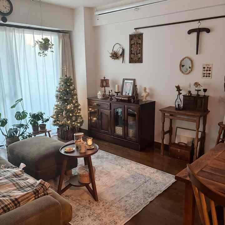 Living room with brown wood tones and white walls, featuring a Christmas tree and vintage furniture in a natural setting