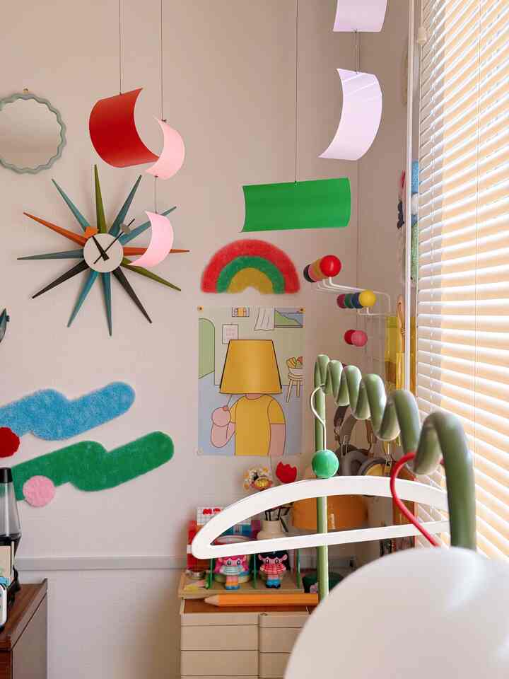 白い壁にカラフルなレトロ風ウォールデコが配置されたミッドセンチュリーモダン風の子供部屋
