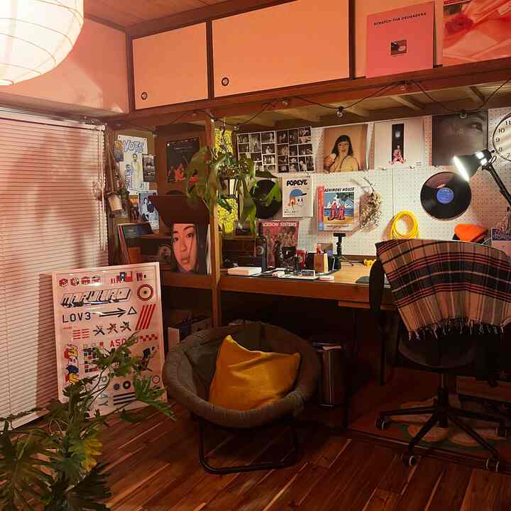 Warm wood tones and vintage wall decor in a small home office featuring plants and a cozy chair