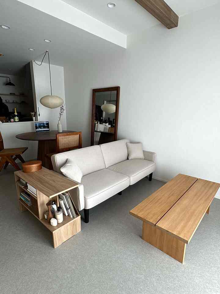 White and wood tone living room featuring sofa, side table, and coffee table in a simple warm Wa-Modern style space