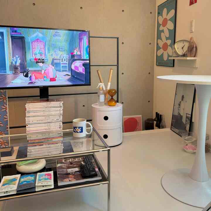 白とステンレスを基調とした一人暮らしのリビング、テレビ台とローテーブルが配置されたモダンな空間