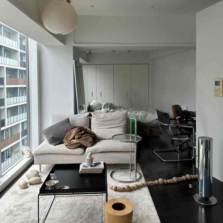 White and gray toned studio living room featuring sofa and coffee table in a modern and minimal space