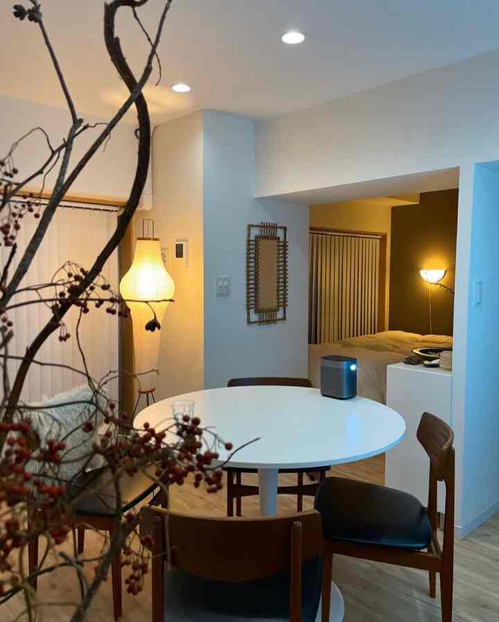 白い壁と茶色の木製家具が配置されたヴィンテージ風のダイニング、暖かい照明が醸し出す落ち着いた雰囲気のインテリア