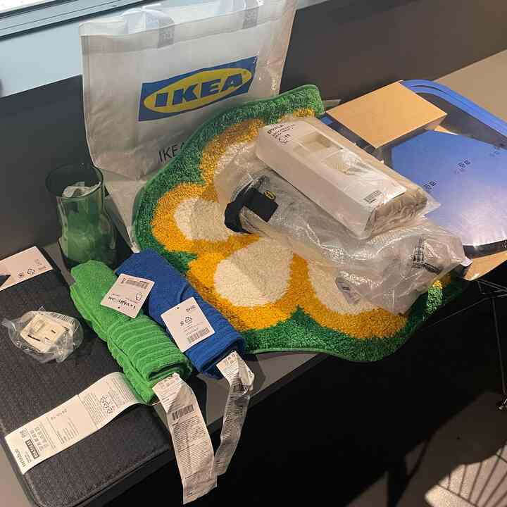 Green and yellow floral rug with colorful towels displayed on table featuring IKEA shopping haul