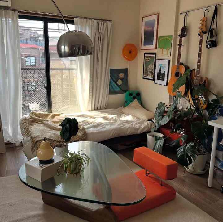 Warm natural-toned 8-tatami bedroom space featuring wall art and foliage plants in a cozy single household interior