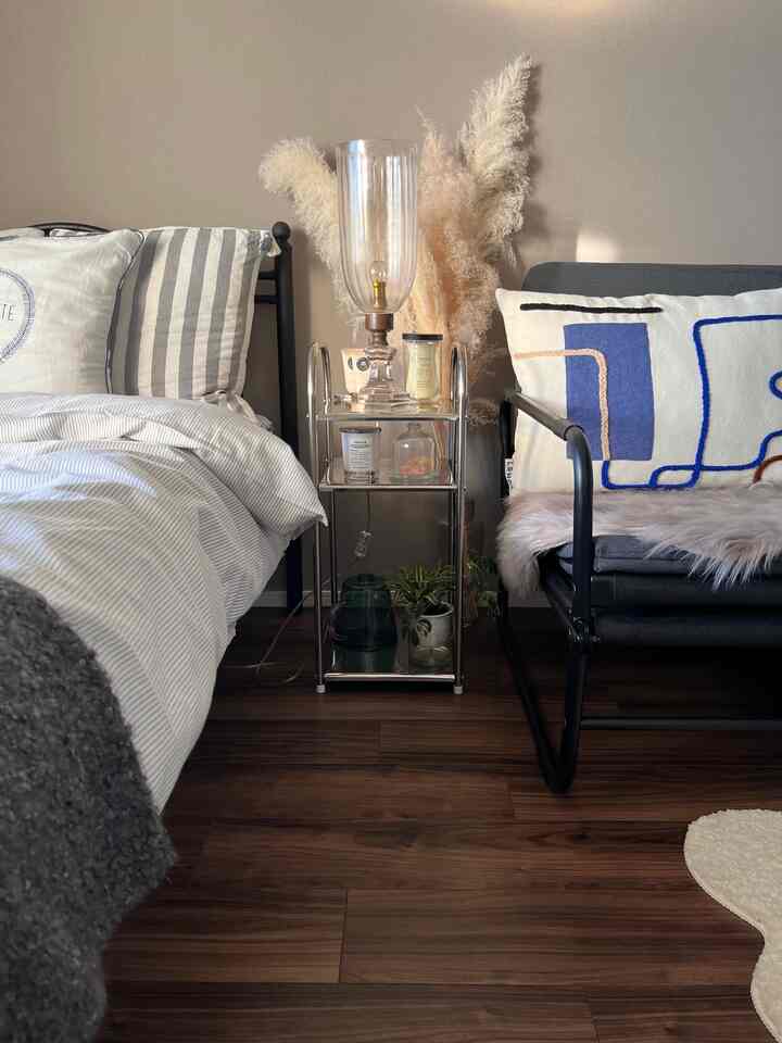 Soft white and brown toned compact bedroom featuring stainless steel side table and modern furniture