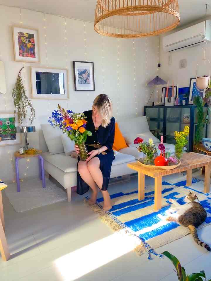 A white and blue living room featuring a sofa and coffee table with colorful bouquets in a natural modern style
