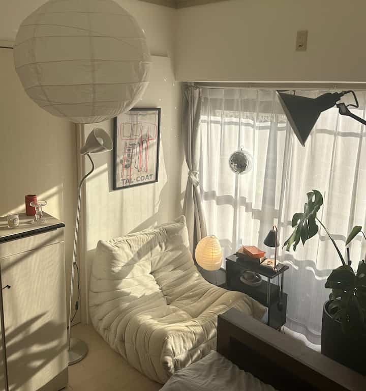 Bright beige natural-toned 5-tatami small room featuring cream sofa, large plant, pendant light, and curtains creating a cozy atmosphere