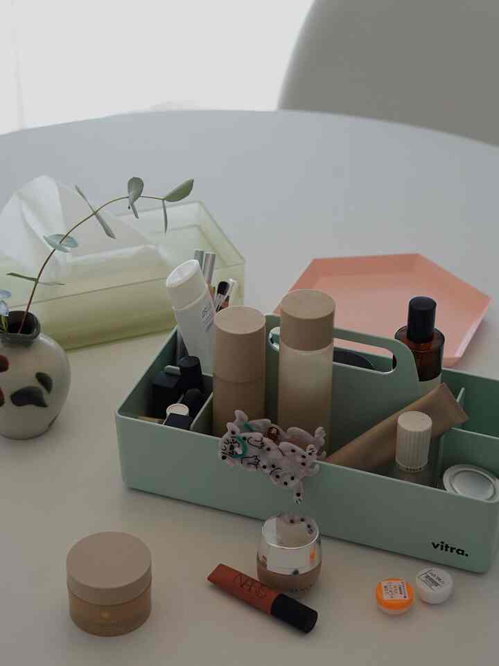 白いテーブルの上にミント色のトレイが置かれ、多彩な化粧品が配置された印象的なダイニングスペース