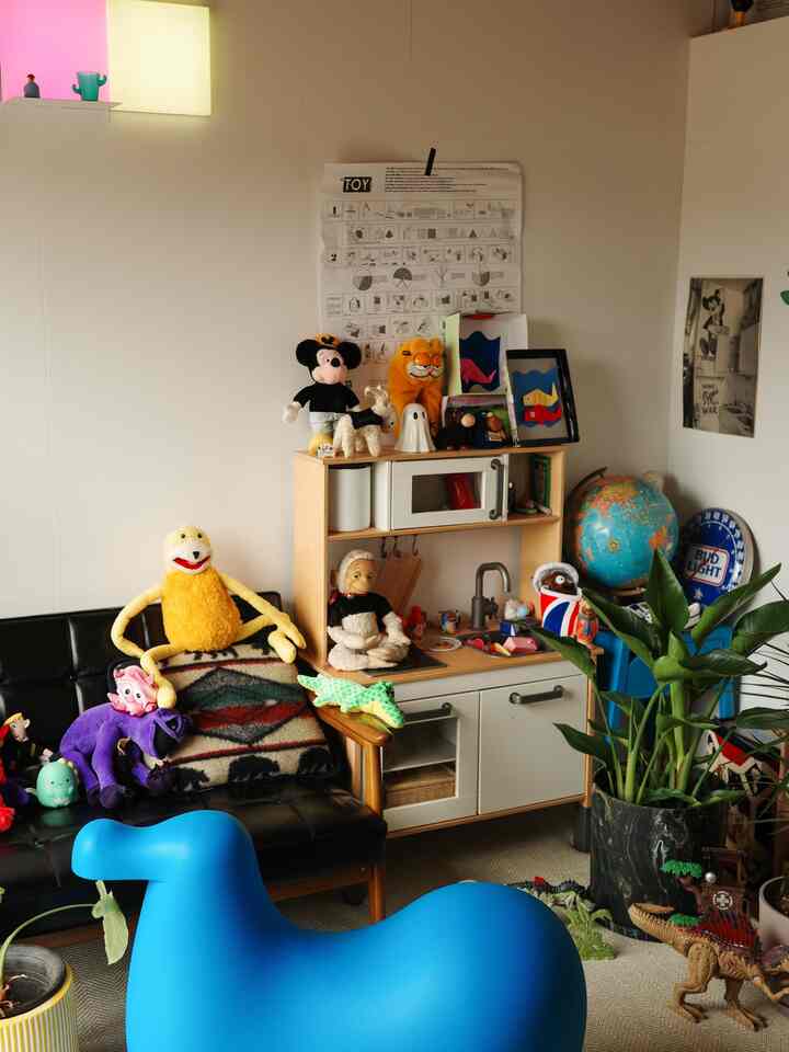 ナチュラルな木目調とブルーが映える子供部屋、トイキッチンや多様なおもちゃが配置された雰囲気のある空間