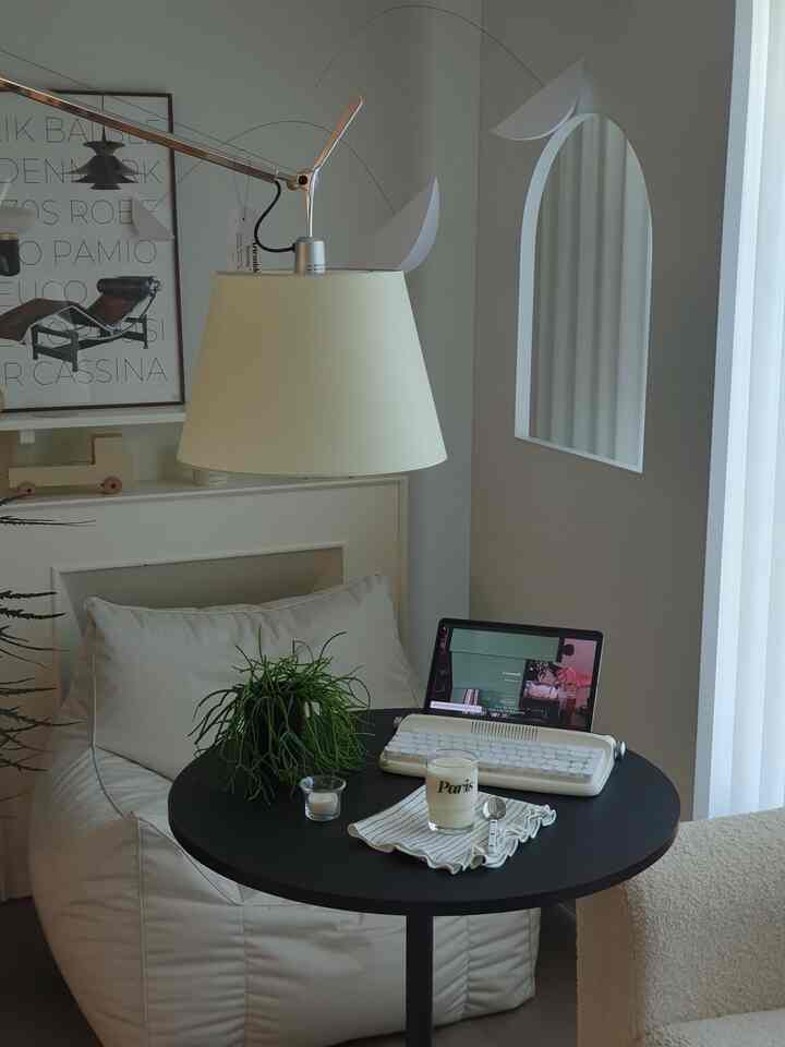 白と黒のトーンのワンルーム空間、ビーンバッグとサイドテーブルに植物とキーボードが配置されたシンプルモダンなインテリア