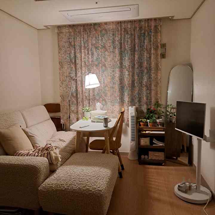 柔らかなベージュと木目調が調和した約10坪のナチュラルモダンなリビング、ソファと木製のテーブル、植物が配置された雰囲気のあるインテリア