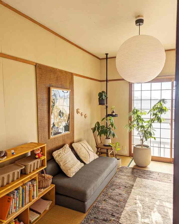 ナチュラルな色調の和モダンリビング、ローソファと木製の本棚、植物が配置された雰囲気のある空間