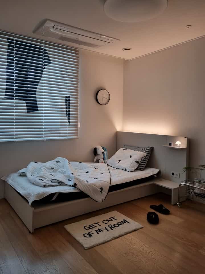 白と黒の調和が美しい子供部屋、ベッドとサイドテーブルが配置された落ち着いた印象のインテリア