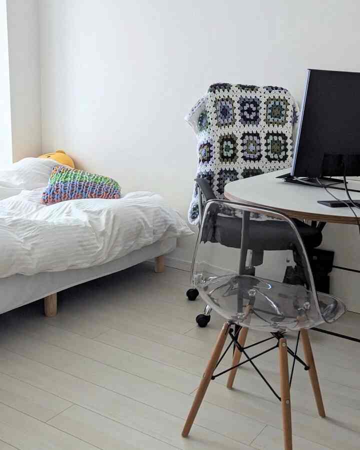 Bright white and natural-toned studio apartment for a single household, blending workspace and bedroom in a cozy setting