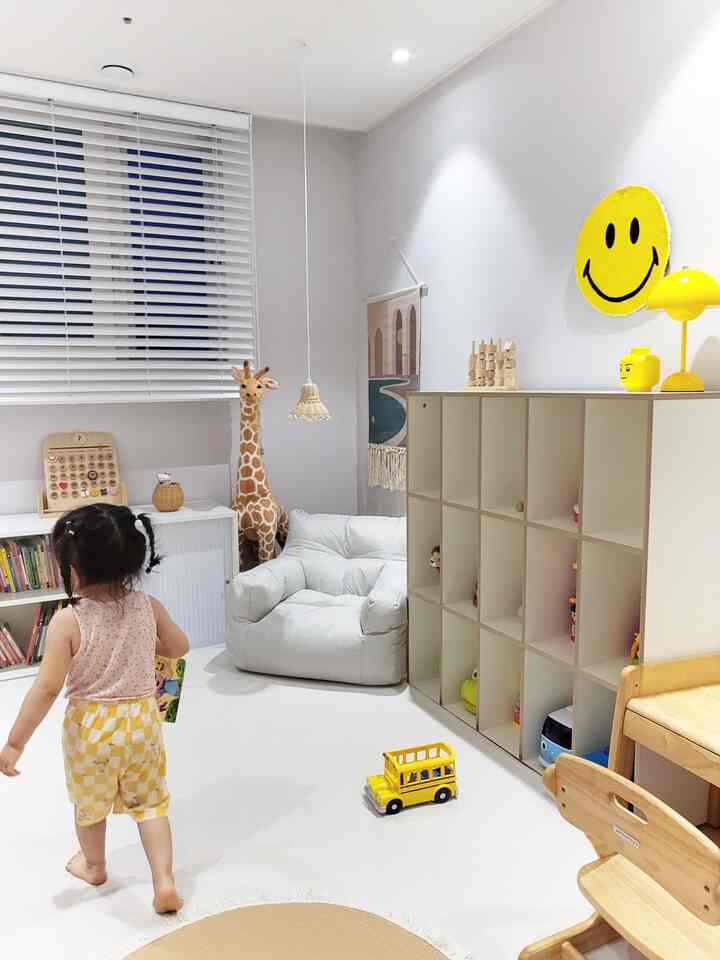 白と木目調の子供部屋、ビーズクッションとおもちゃ収納が配置された居心地の良い空間